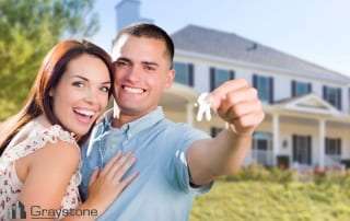 Married couple at home displaying their keys