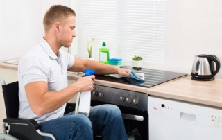 Man in wheelchair cleans induction stove installed in an accessible home