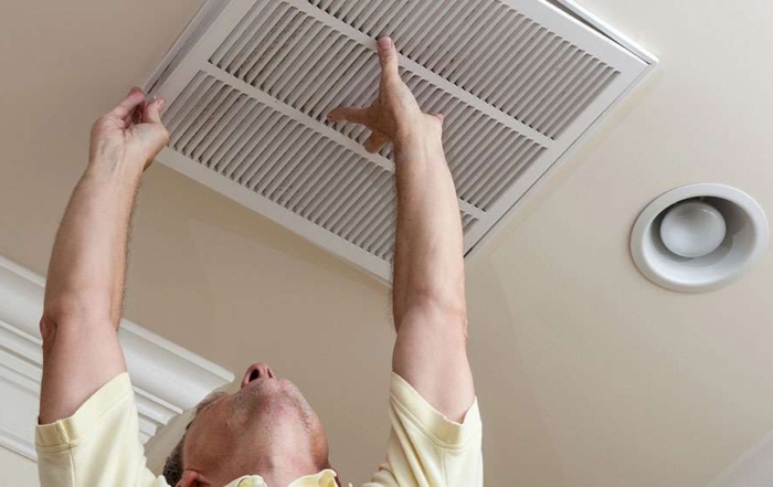 Man changing a ceiling air filter