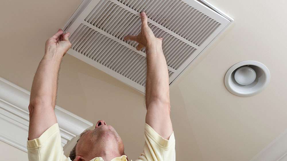 Seasonal Home Maintenance: Save Money & Add Value Man changing a ceiling air filter