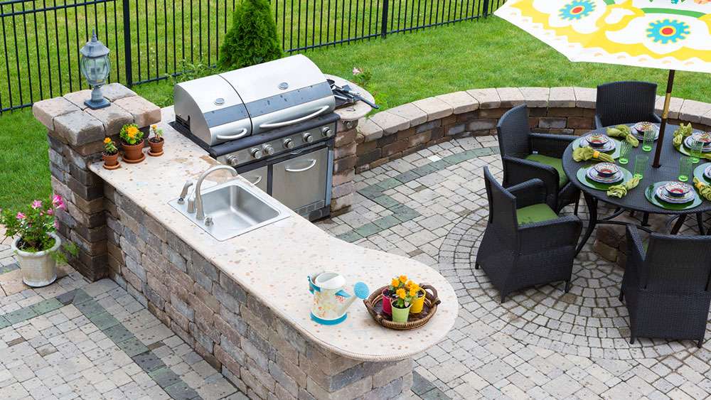 Outdoor Living Enhancements: Creating a Backyard You'll Love Outdoor kitchen and dining table on a paved patio