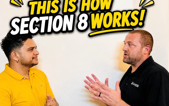 Two men discuss in front of a wall sign that reads 'NO MAN, THIS IS HOW SECTION 8 WORKS!'