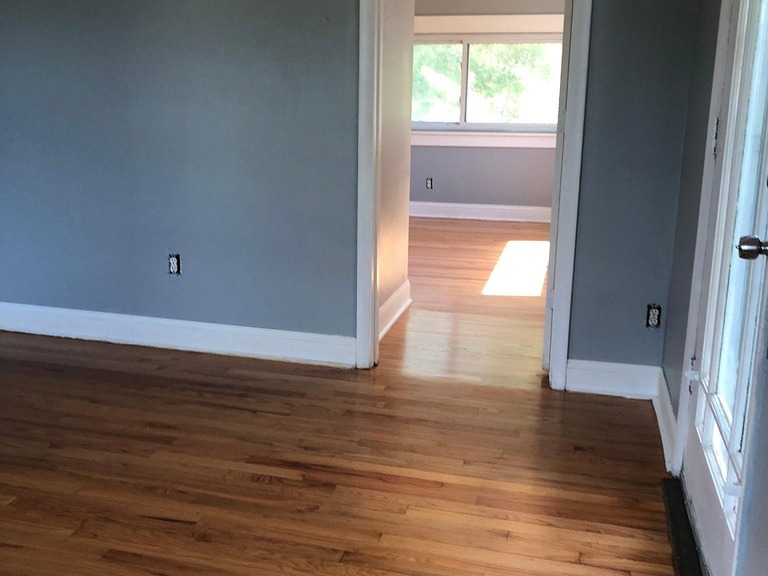 imgi_591_69dfa46de36dfa03c0964ce3cfe278dc-cc_ft_1536 - Graystone Investment Group Room with blue-gray walls and hardwood floor, open to a sunlit adjoining room with windows.